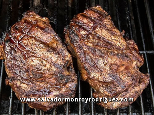 Salvador Monroy Rodriguez cocinando unos cortes en la parrilla.